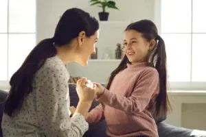 Madre e hija conversando en el sofá