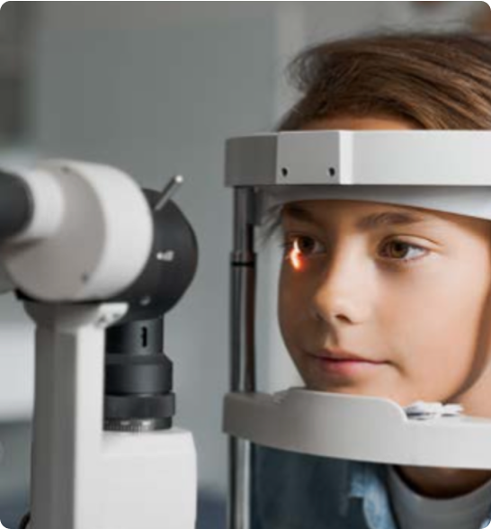 Niño realizándose un examen ocular con un equipo de medición de la visión